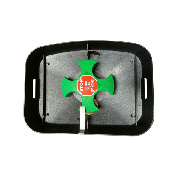 Machine top plate with the green ball feeder wheel and a Stop, do not turn by hand label