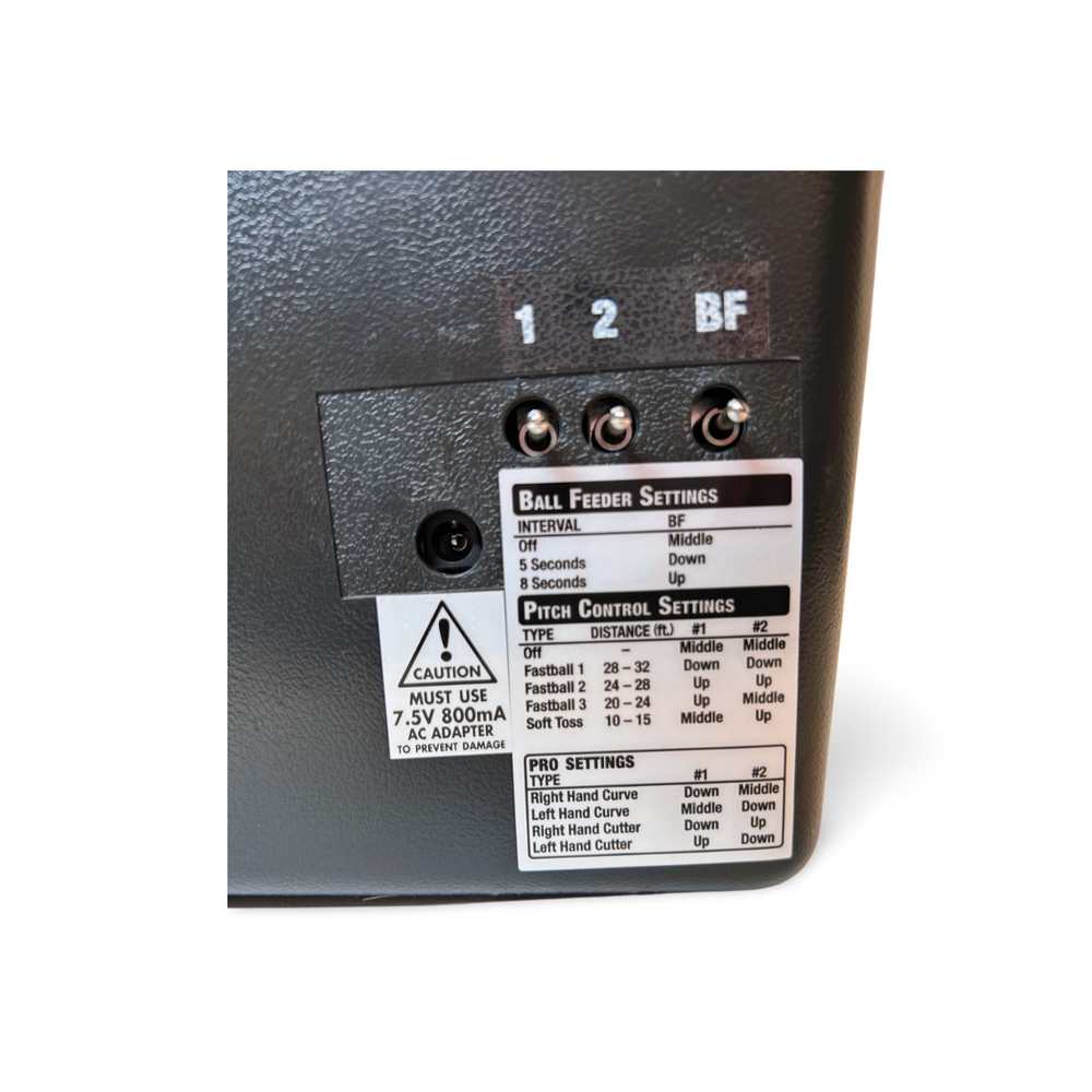 Close-up of the switch panel with the printed ball feeder and pitch control settings chart